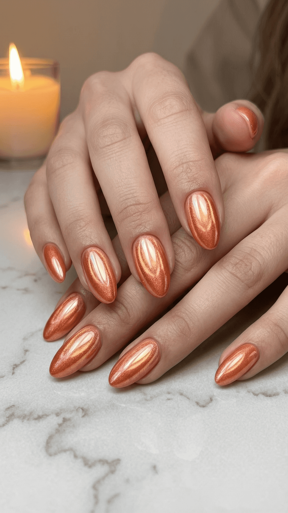 Almond-shaped nails with copper metallic finish and glossy shimmer.