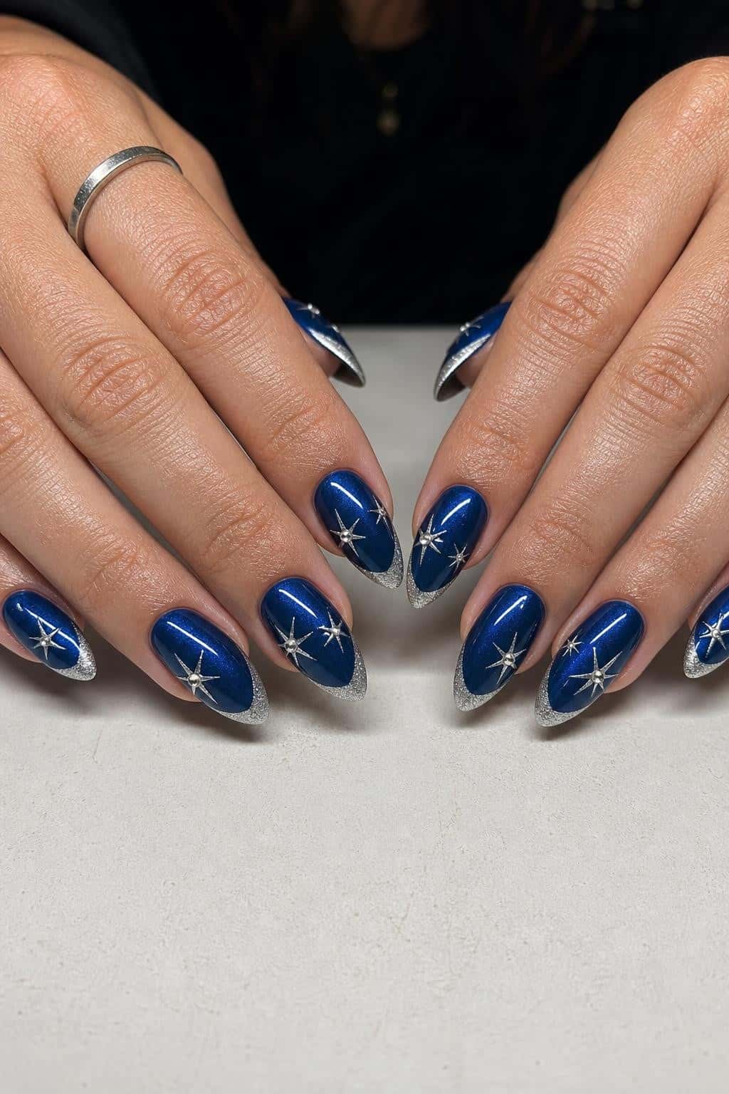 Long blue glitter stiletto nails with holographic shimmer and ombre tips.