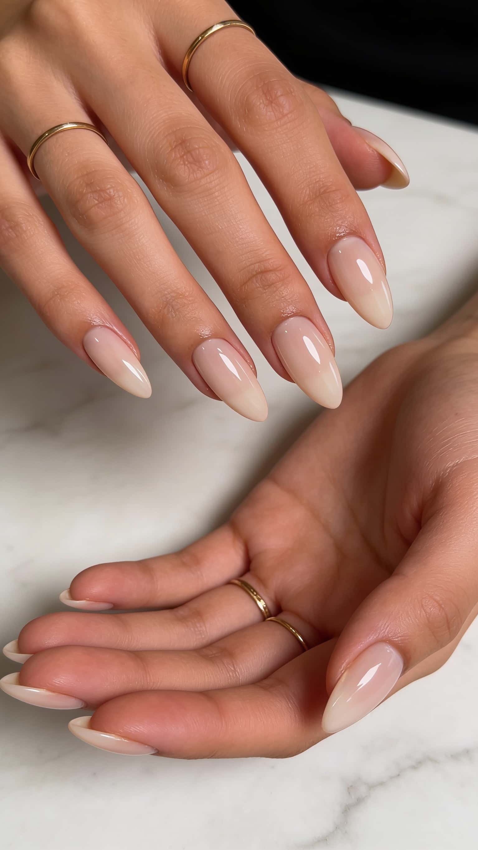 Long almond nails feature a sheer nude pink to creamy white ombre with a glossy finish.