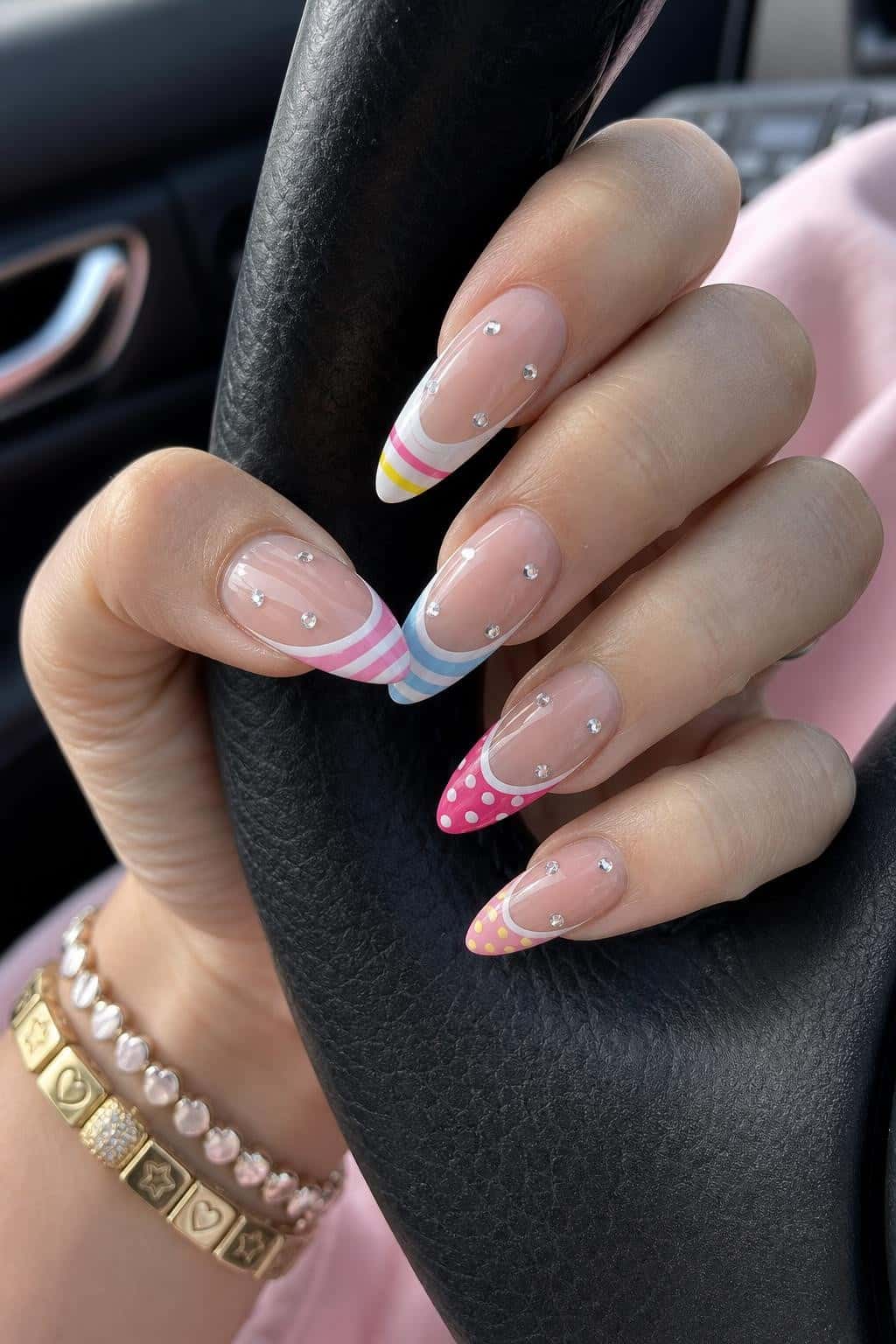 Long almond nails with pastel French tips and mixed patterns.