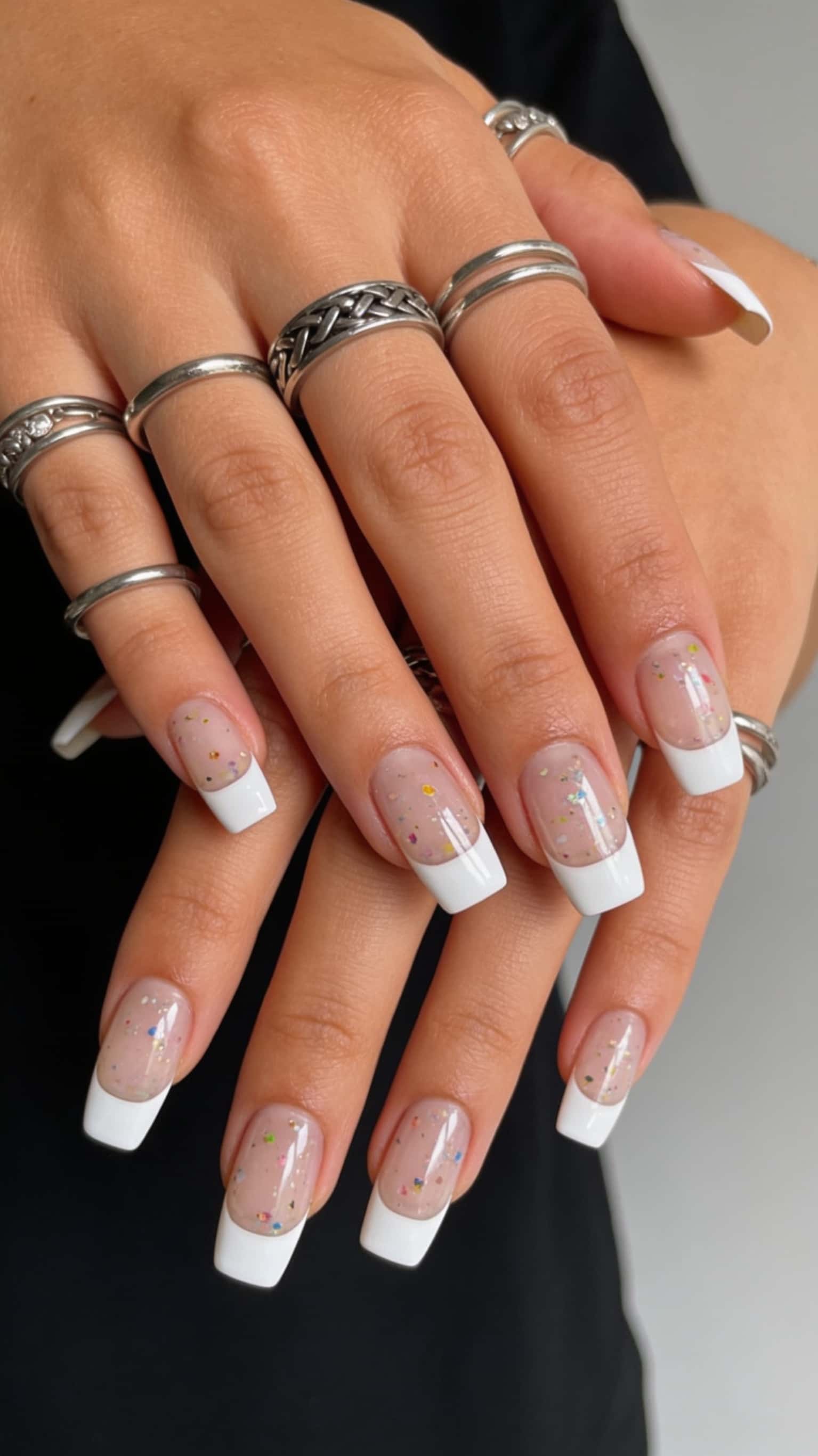 Square-shaped nails with a playful confetti glitter design and white tip.