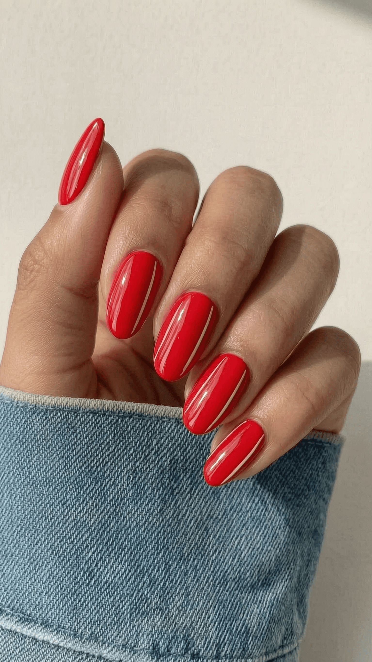 Vibrant red oval nails with two thin white vertical stripes on each nail and a high-gloss finish.