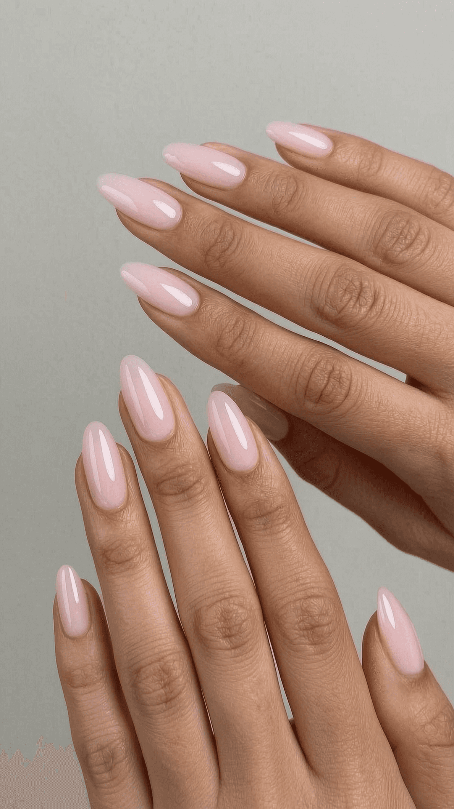 Medium-length almond nails with a high-gloss, sheer milky pink gel polish.