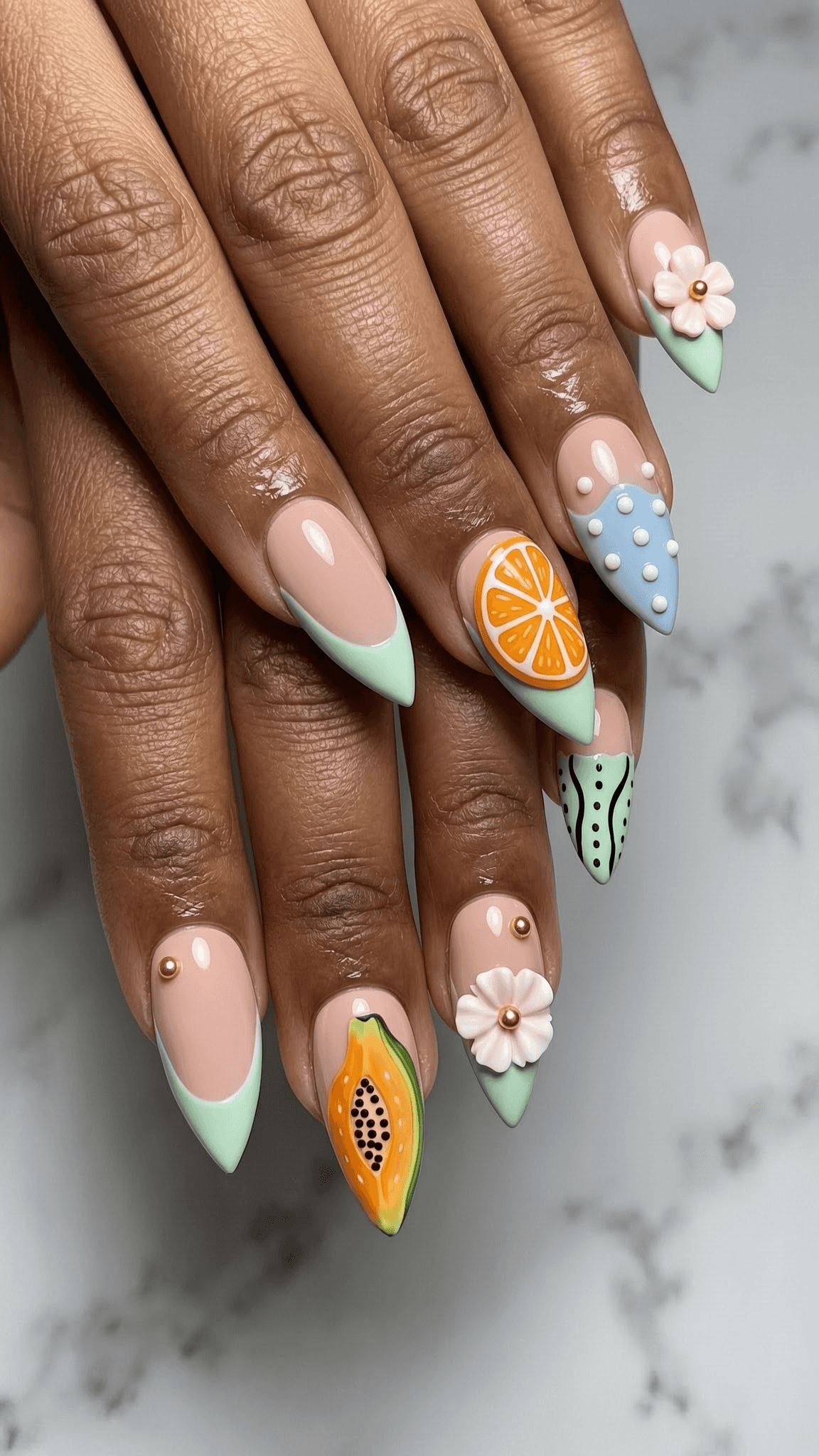 Long stiletto nails with a nude base and pastel mint green French tips.