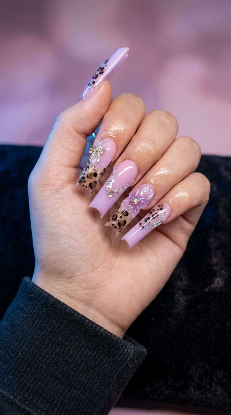 After image: Extreme long coffin nails with lavender ombre, glitter, and leopard print, glossy finish, on a hand resting on dark fabric.
