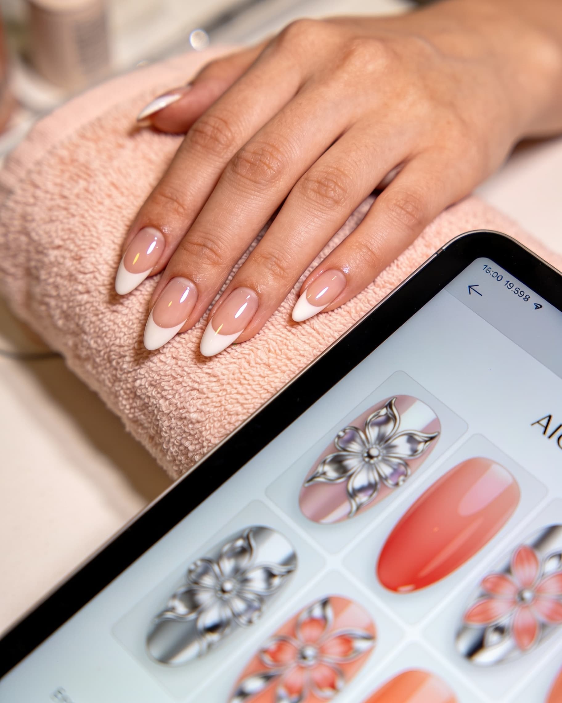 Nail tech running an AI nail preview on a client hand photo during an in-salon consultation