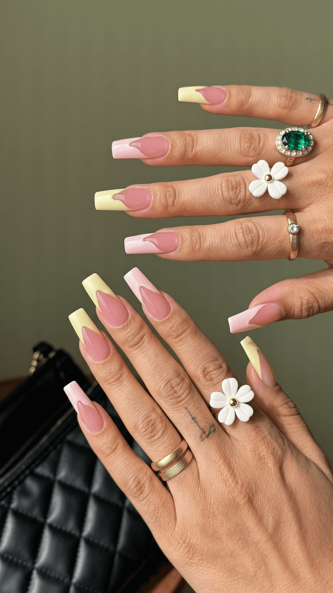 Long coffin nails with a sheer nude base and alternating pastel pink and yellow V-cut French tips.
