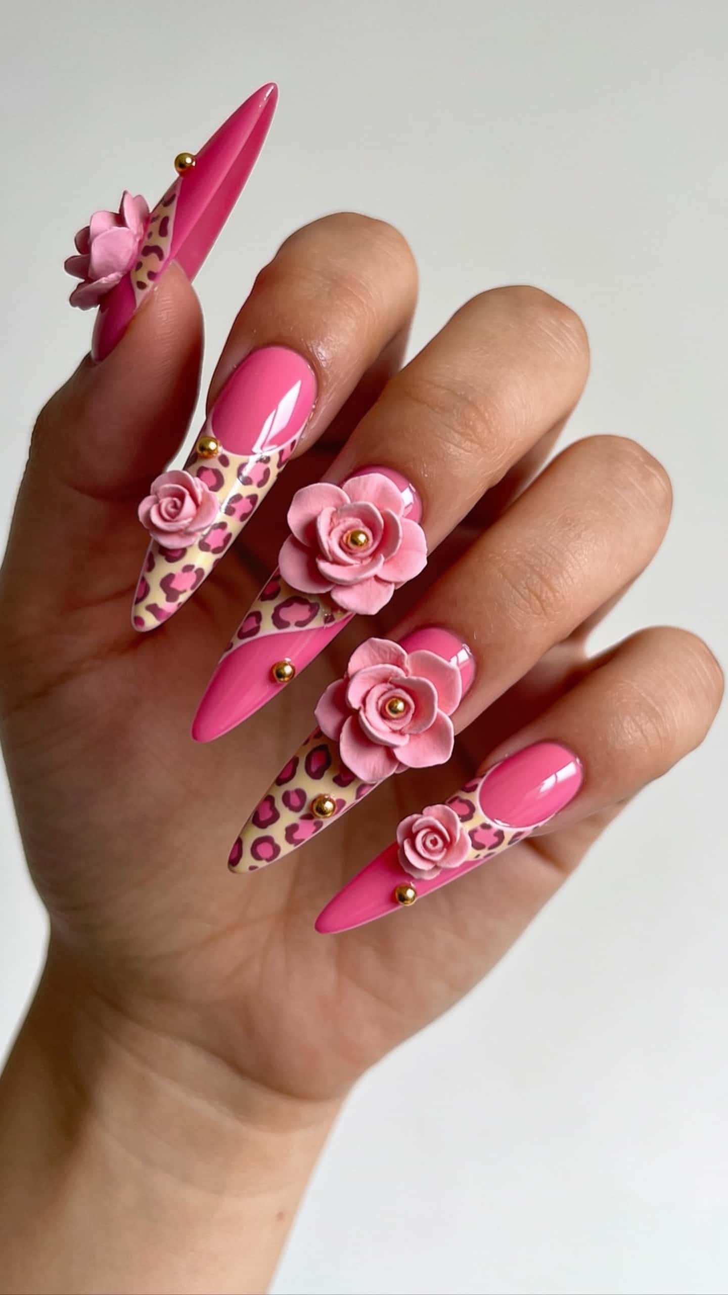 Long stiletto nails with hot pink, pink leopard print, 3D pink roses, and gold studs.