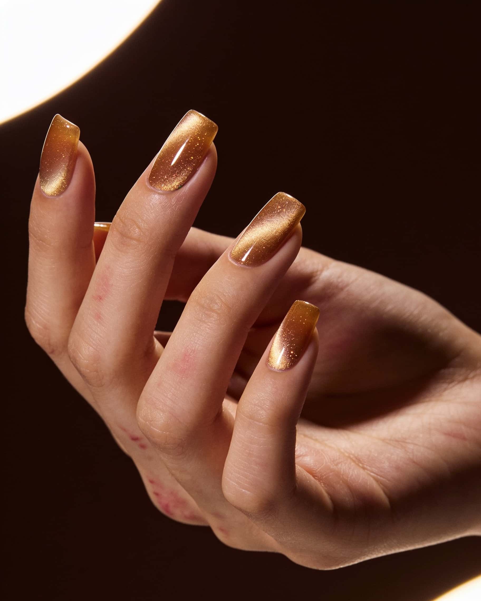 Warm golden metallic nail art with subtle gradient effect, smooth glossy finish, and delicate texture reminiscent of fine silk, applied on square-shaped nails